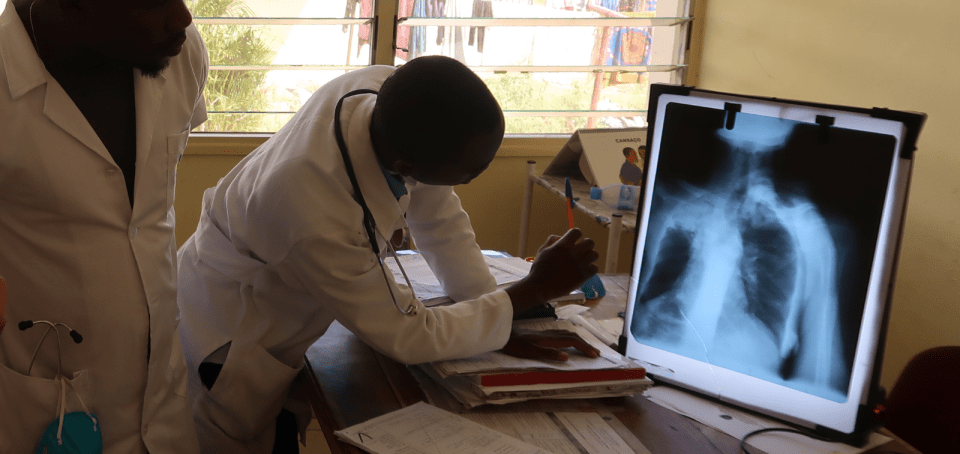 Two men check a TB Diagnosis on a computer screen