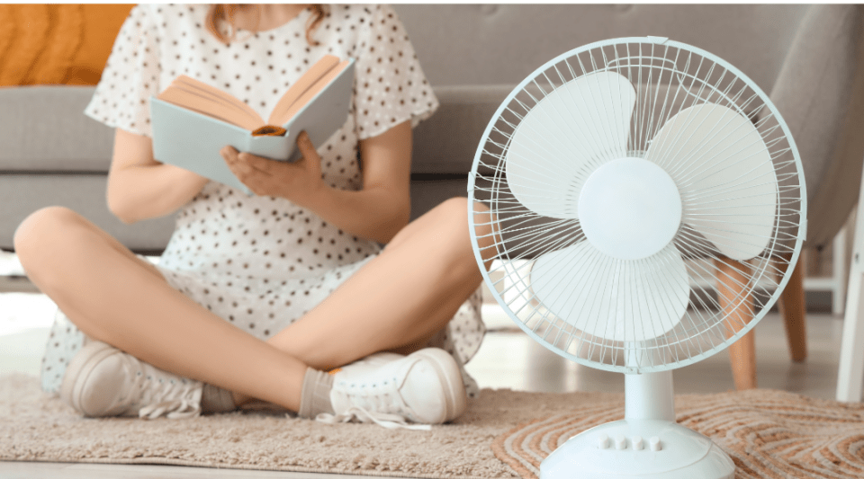 noia llegint amb un ventilador